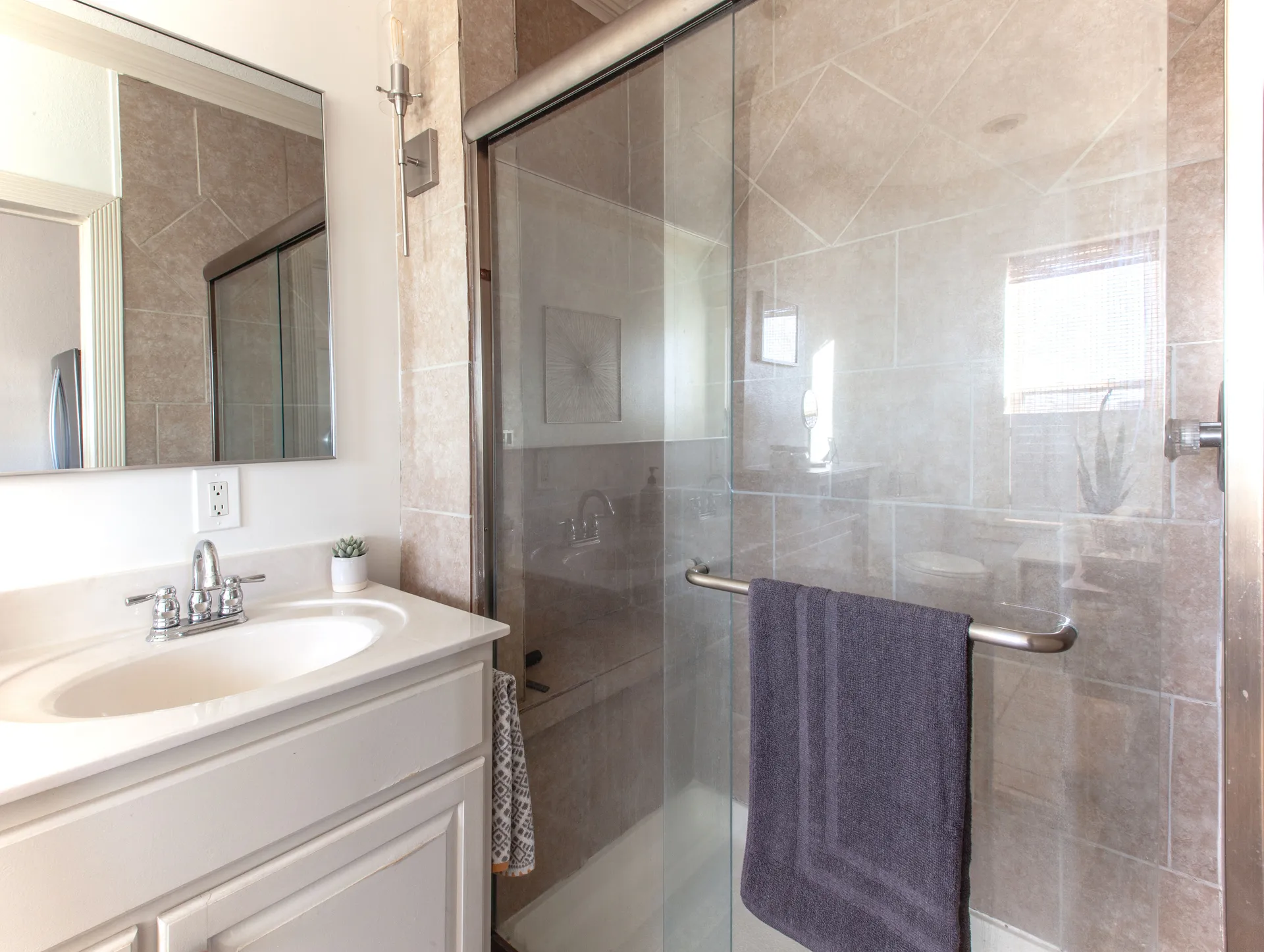 Loft B full bathroom across the loft, with a double-sink vanity and glass-door walk-in shower